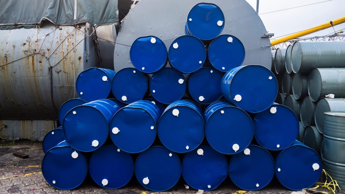 Stacked blue chemical drums in a storage yard